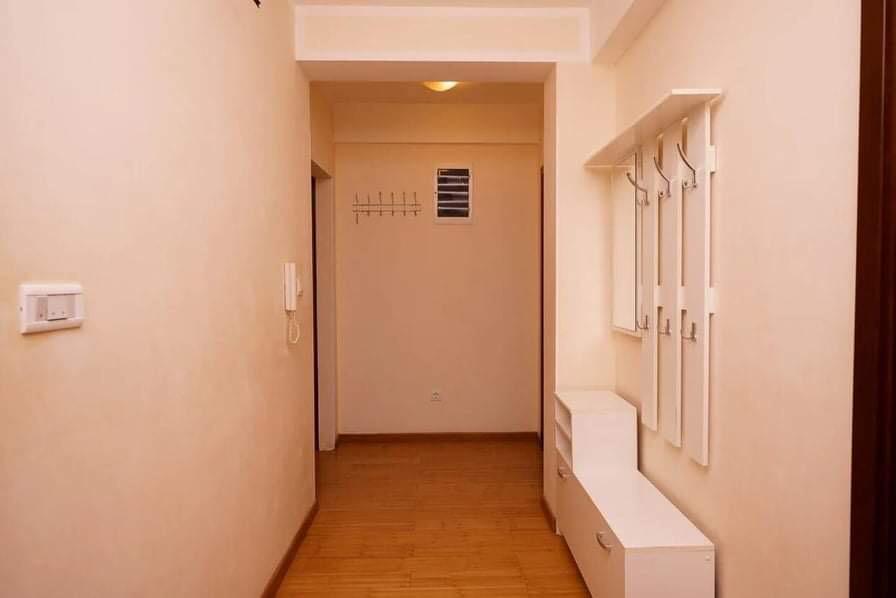 Bright hallway in an apartment in Budva, Montenegro: white furniture, a coat rack, and laminate flooring.