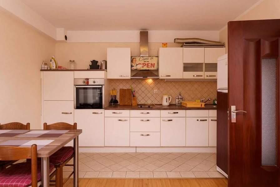 Bright kitchen with built-in appliances and a dining area in an apartment in Budva, Montenegro.
