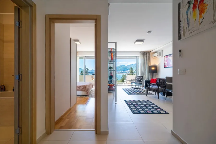 Hallway view showing a bedroom and living room with a sea view through the window.