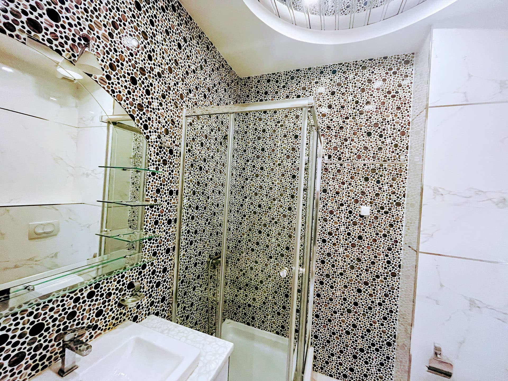 Modern bathroom in an apartment in Budva, Montenegro: shower cabin and mosaic tile wall finish.