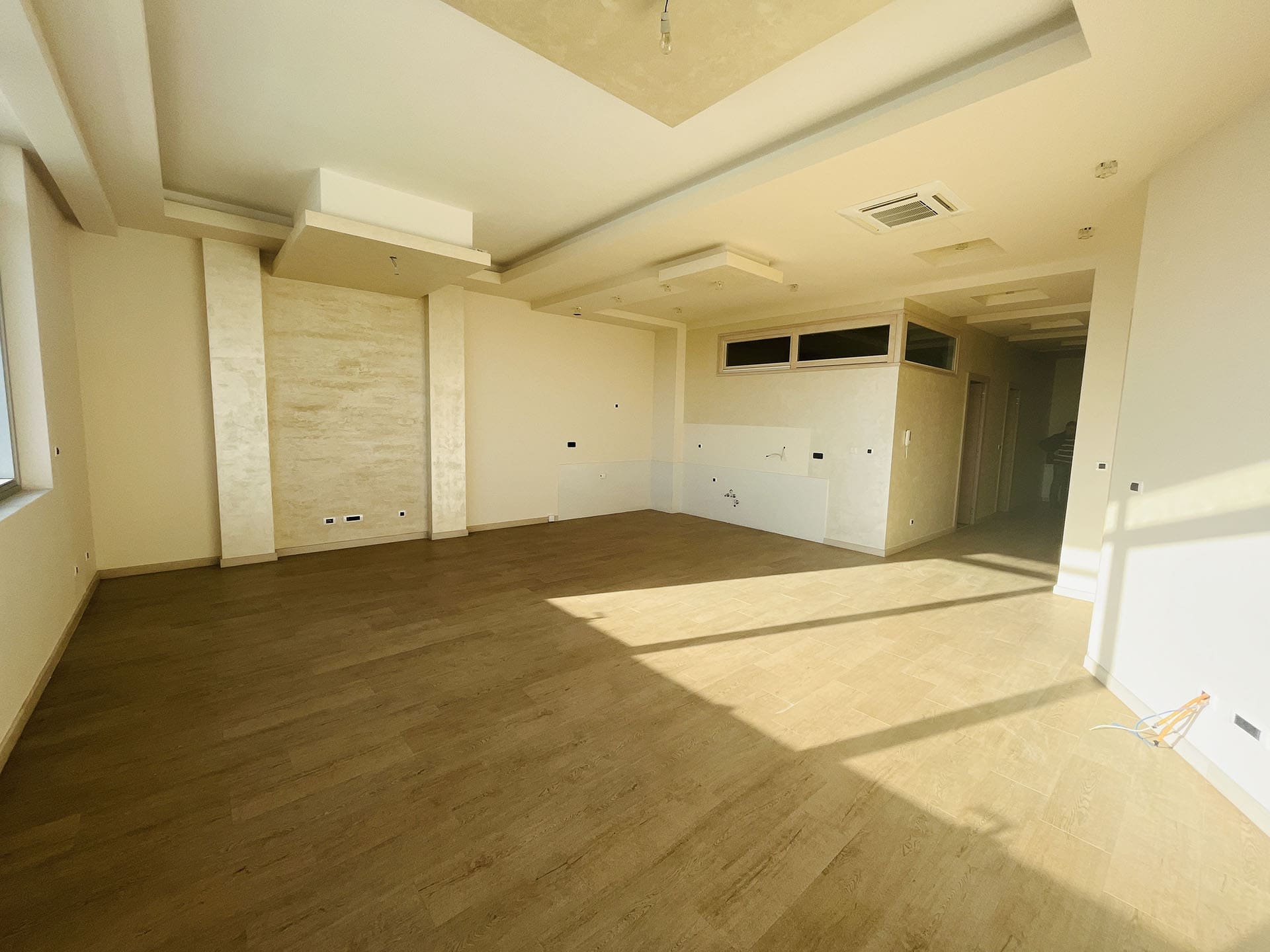 Spacious living room with finished interior and a multi-level ceiling in a new apartment in Budva, Montenegro.