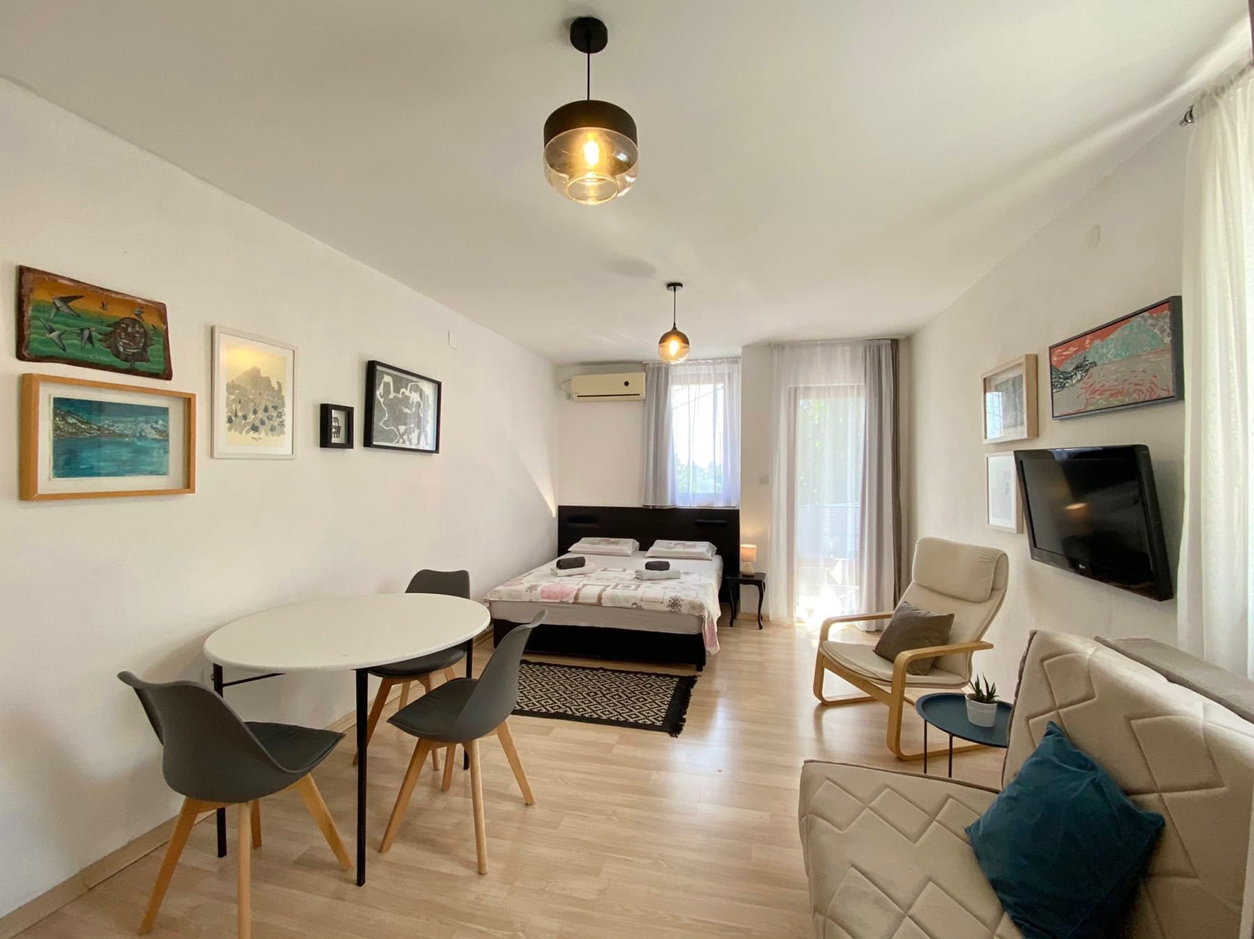 Bright bedroom in a house, Shushan, Montenegro: double bed, dining area, armchair, and access to the balcony.