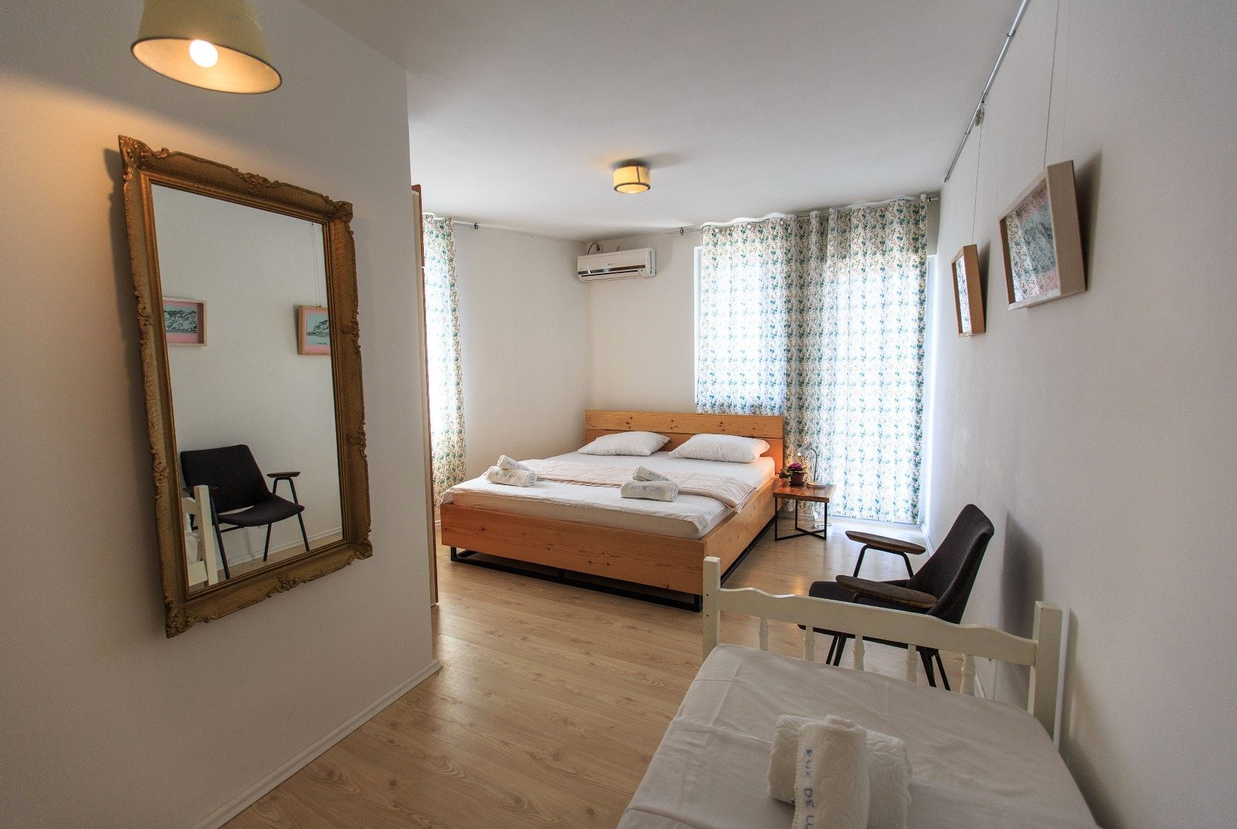 Bright bedroom with a double bed, a mirror in a gold frame, and furniture in a house in Shushan, Montenegro.