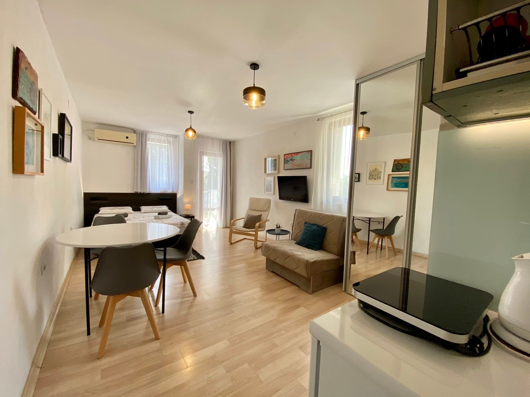 Living room interior in a house in Shushan, Montenegro: a bright studio with a double bed, sofa, and dining area.