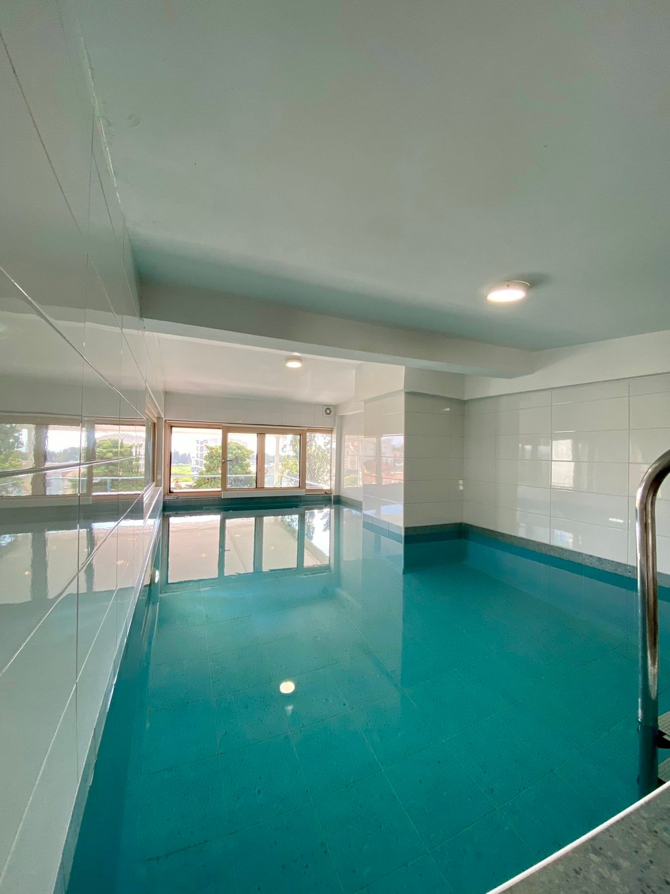 Indoor pool with panoramic windows in the house, Shushan, Montenegro: bright tiled finishes and a modern interior.