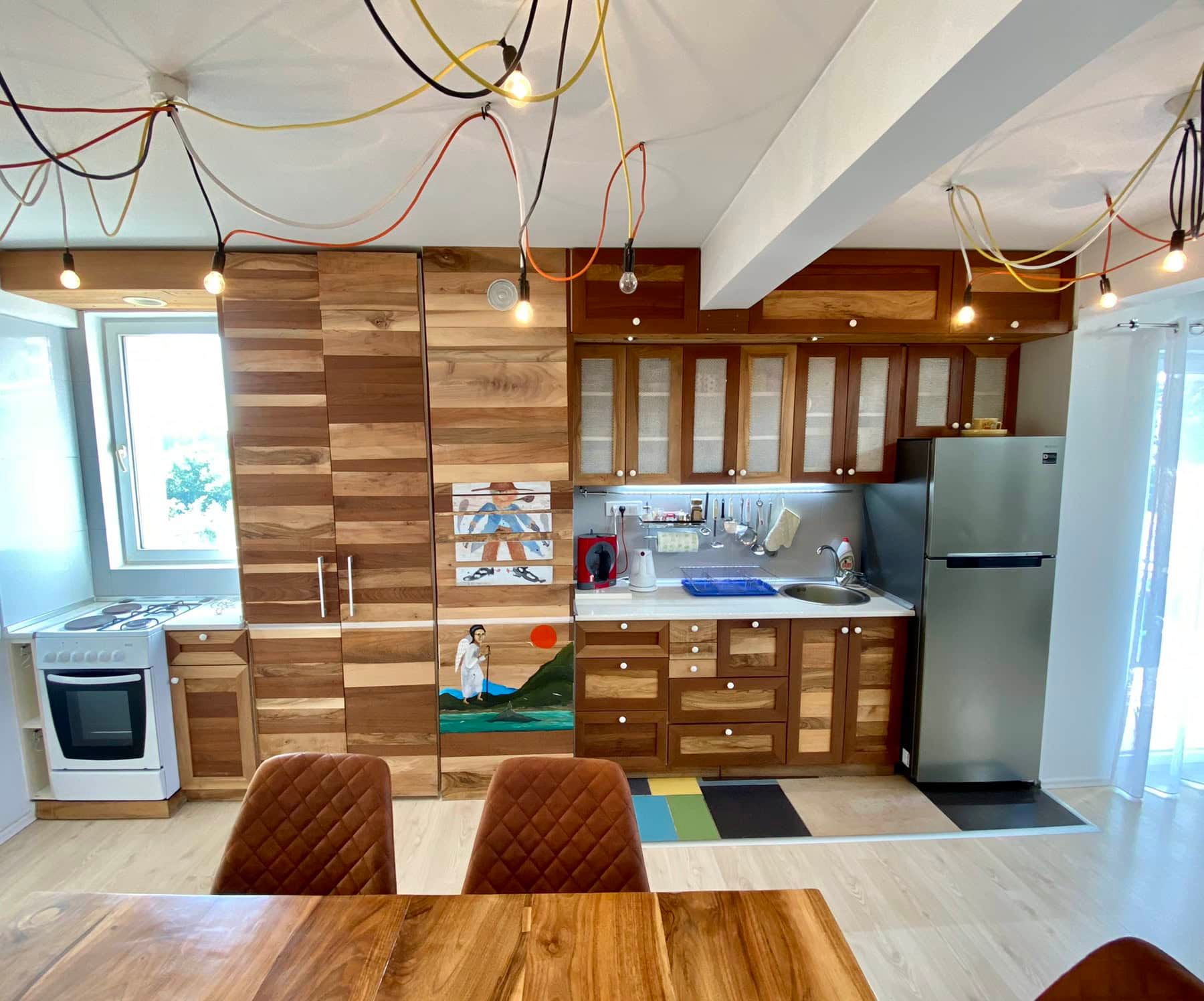 Modern kitchen with wooden fronts in a house in Shushan, Montenegro: stylish interior, dining area, and decor.