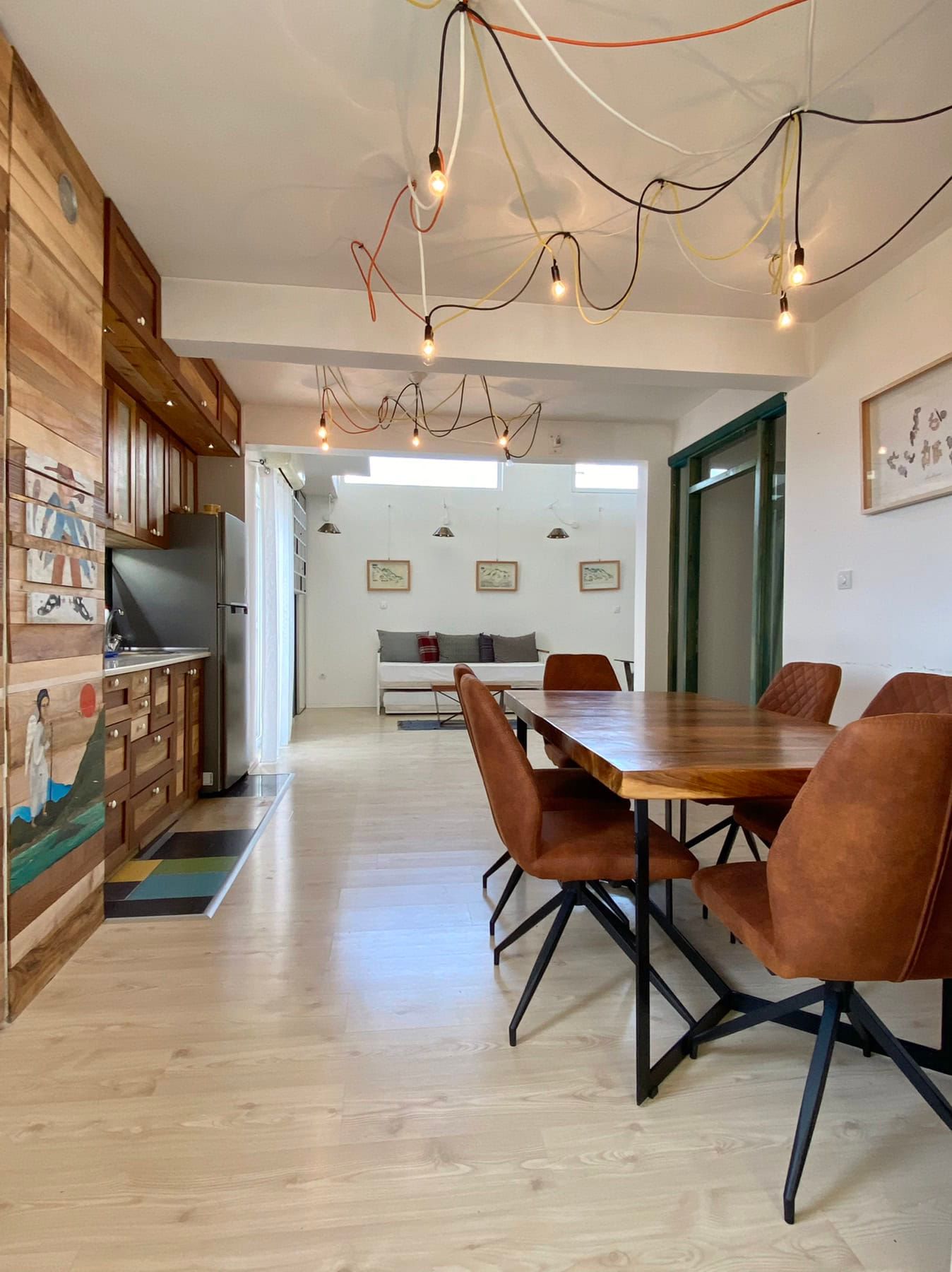 Living room with dining area in a house, Shushan, Montenegro: wooden table, leather chairs, and designer lighting.