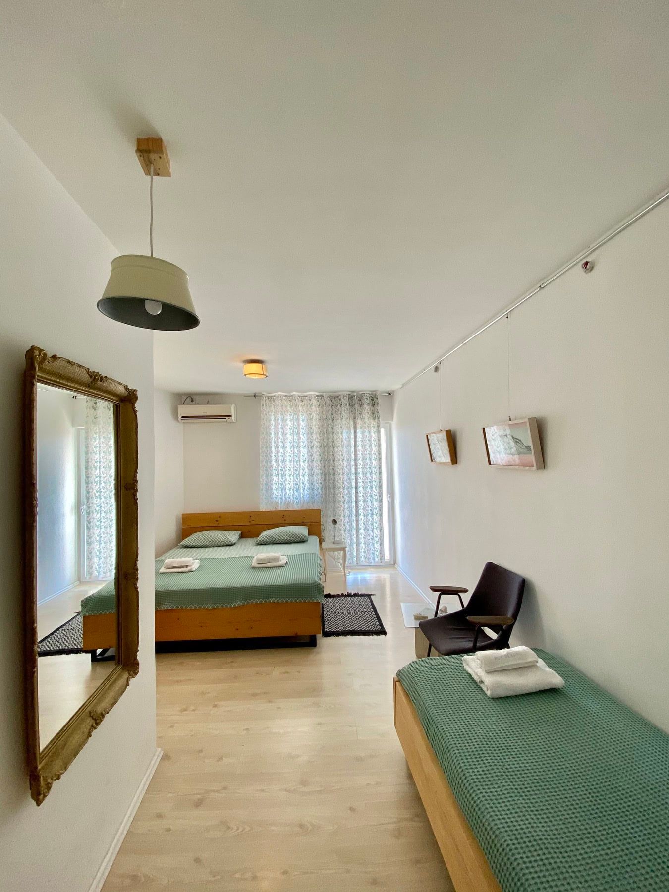 Bright bedroom with a double bed and mirror in a house in Shushan, Montenegro, with access to the balcony and air conditioning.