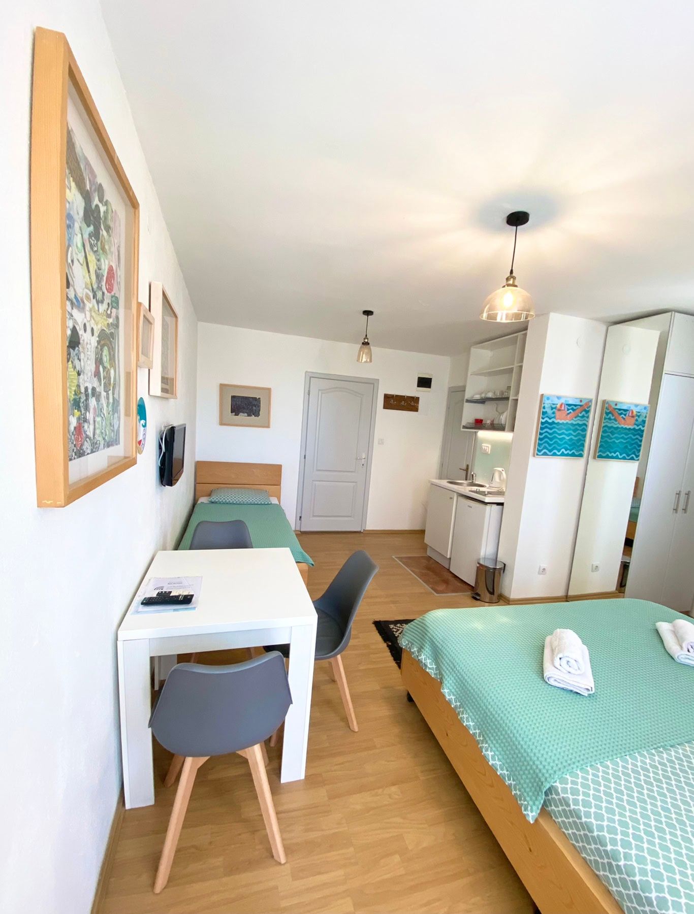 Bedroom interior in a house in Shushan, Montenegro: a double bed, dining area, and a kitchenette with modern furniture.