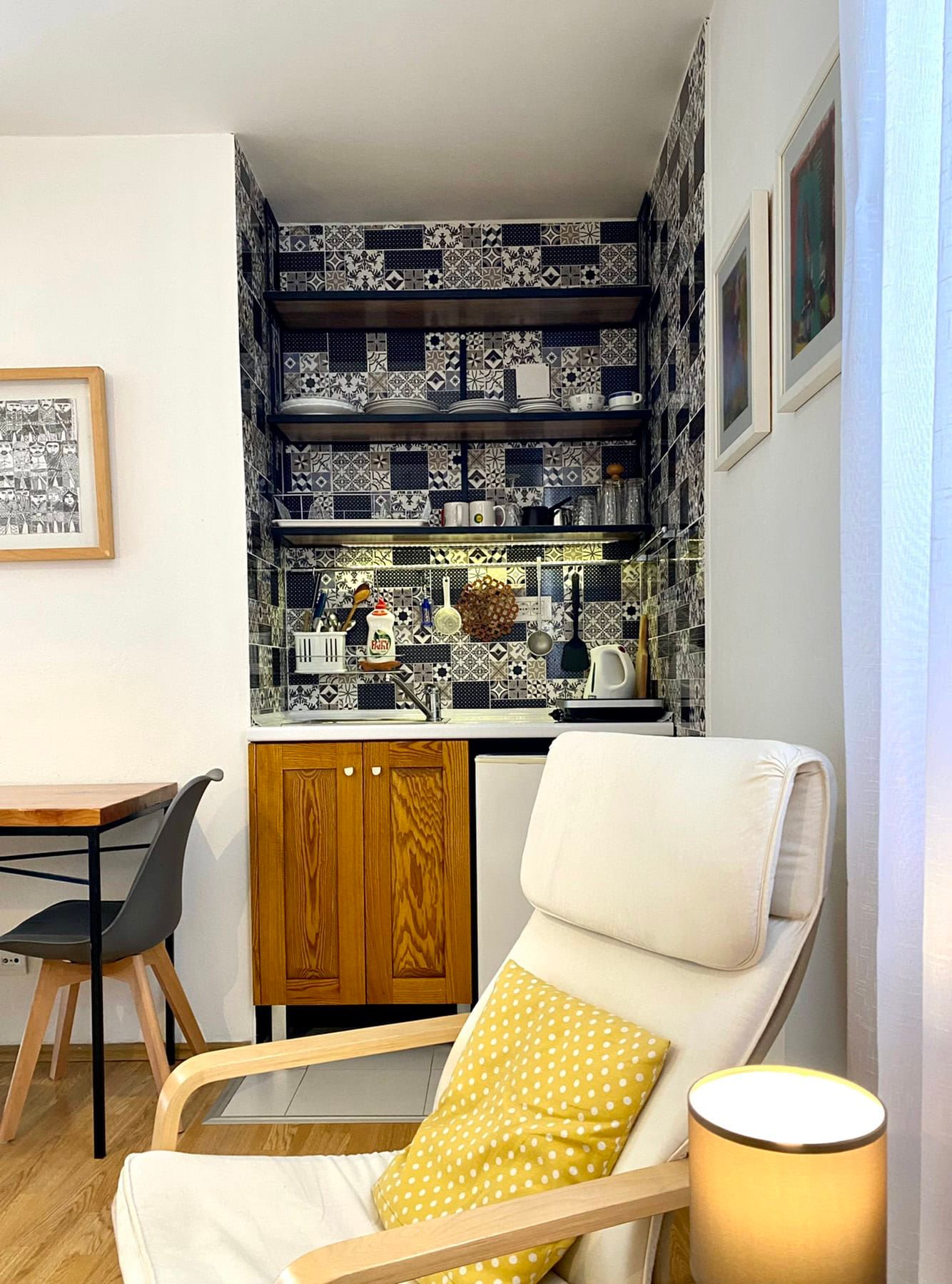 Kitchen in a house in Shushan, Montenegro: wooden cabinets, patterned tile, open shelves, and a cozy armchair in the interior.
