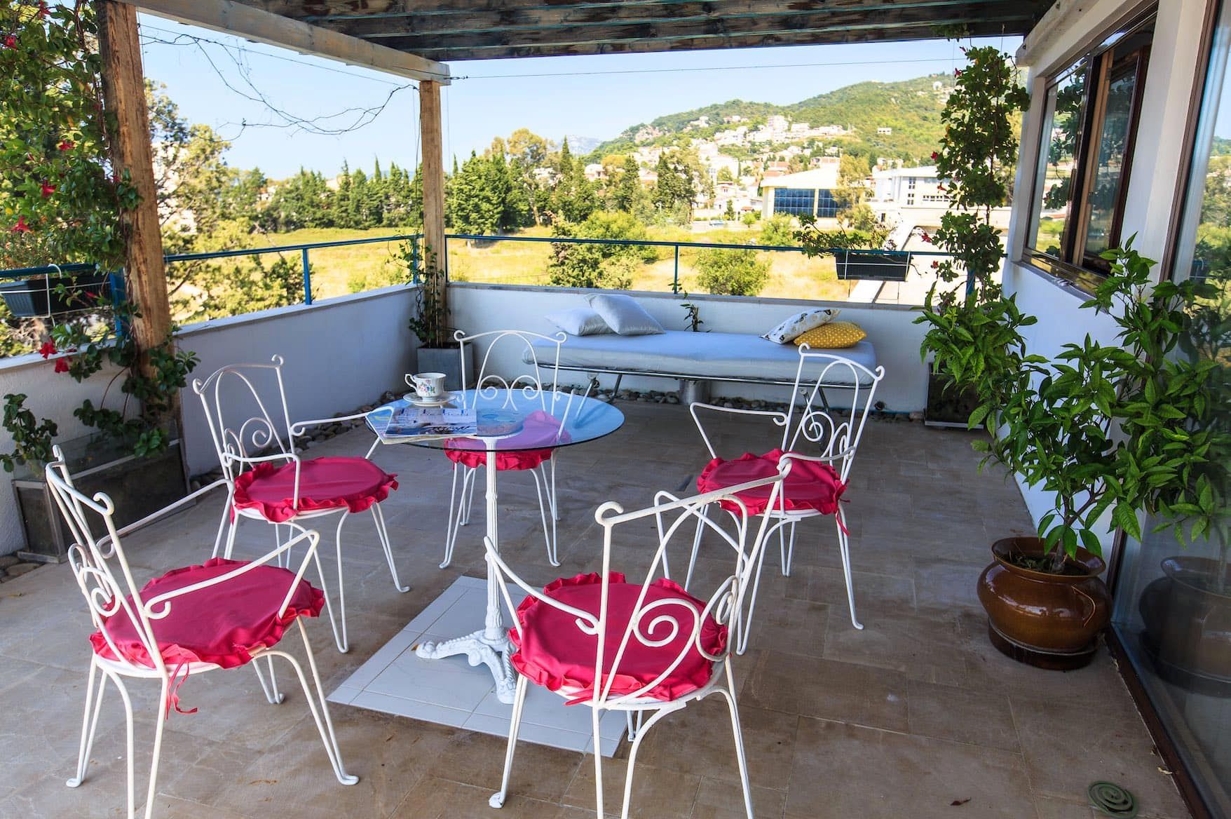 Cozy terrace with wrought-iron furniture and mountain views in a house, Shushan, Montenegro. Spacious balcony with a seating area.
