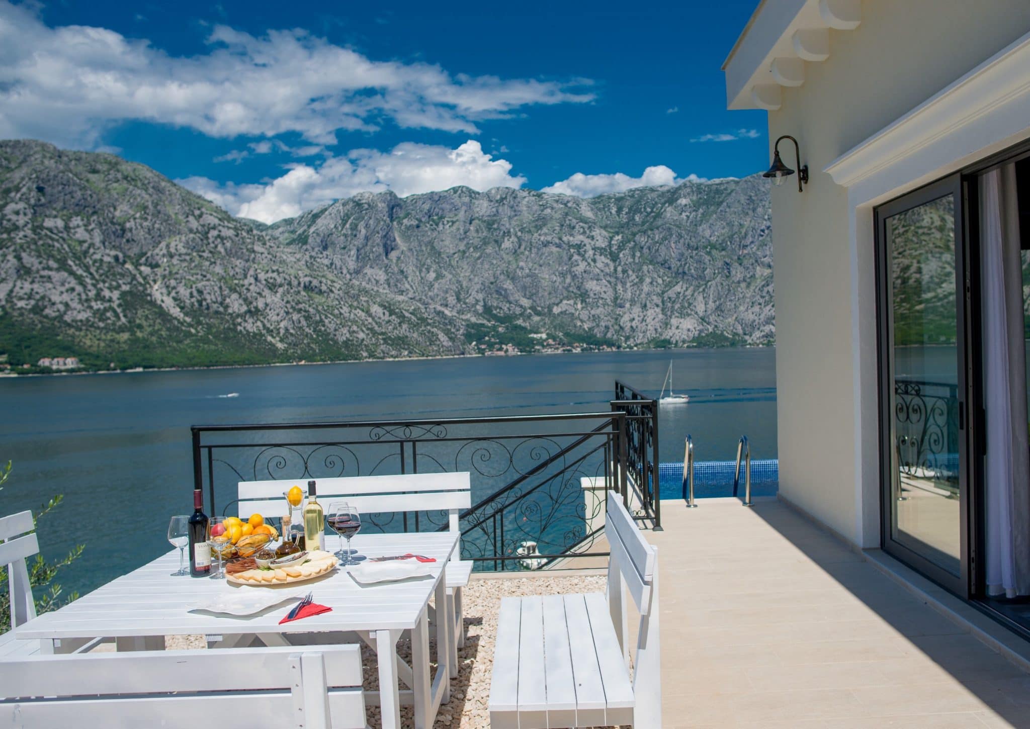Villa terrace in Stoliv, Montenegro: dining area, view of the Bay of Kotor, mountains, and private pool.