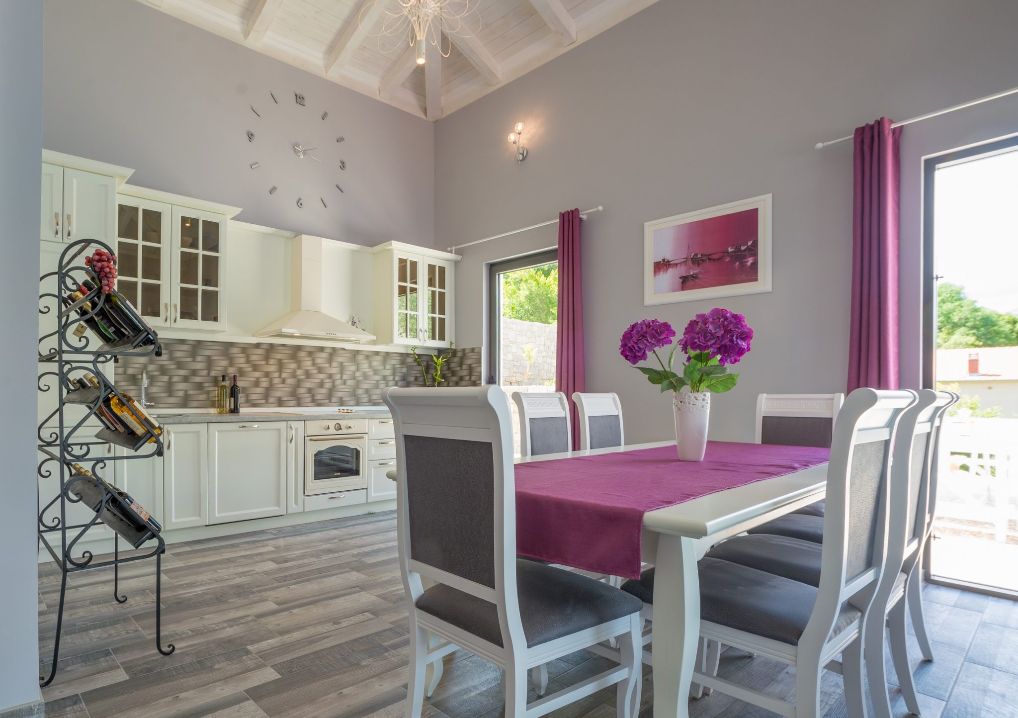 Bright kitchen-dining room in a villa in Stoliv, Montenegro: white furniture, high ceilings, dining area with decor.