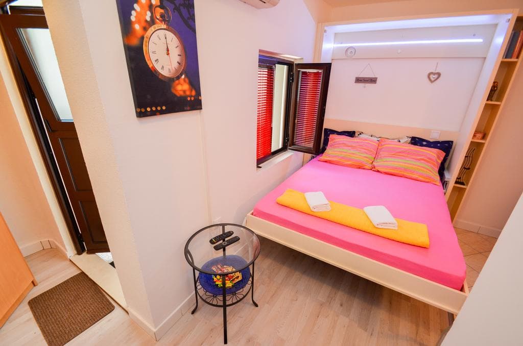 Cozy bedroom with a double bed in a house in Kotor, Montenegro: bright interior, modern furniture and decor.