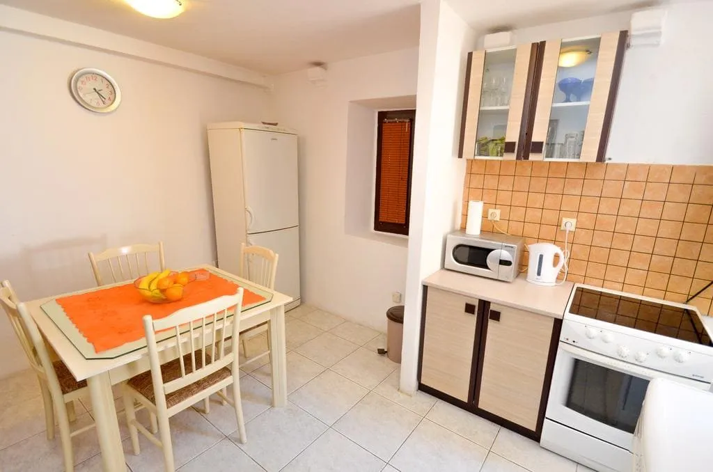 Kitchen with dining table, refrigerator, stove, microwave, and upper cabinets visible.