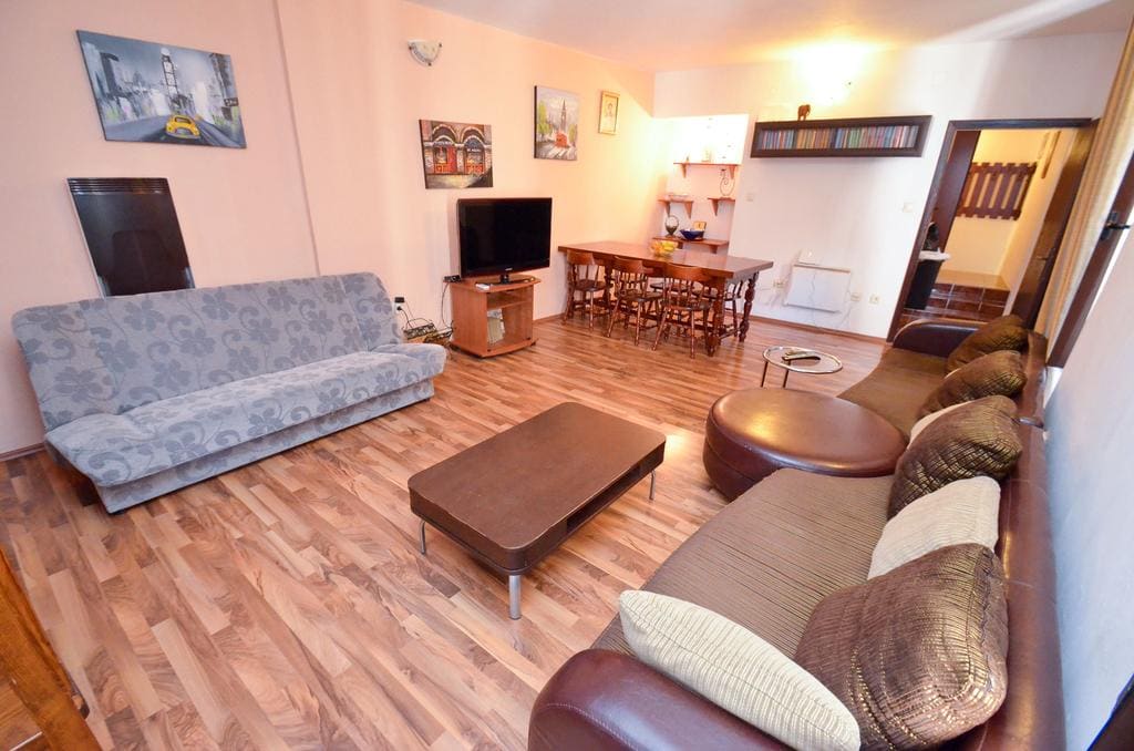 Spacious living room with soft furniture, dining area, and laminate flooring in a house for sale, Kotor, Montenegro.