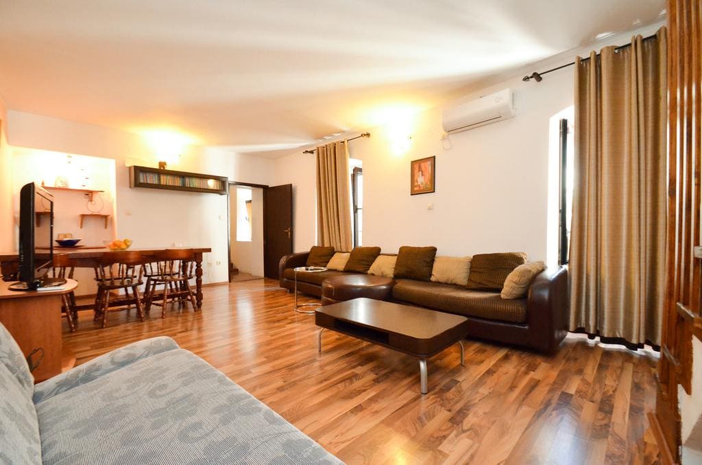 Spacious living room with a leather sofa and wooden floor in a house in Kotor, Montenegro.