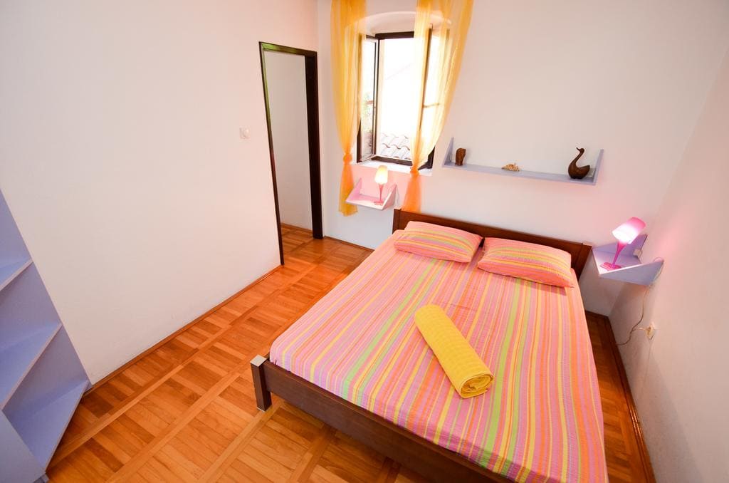 Cozy bedroom with a double bed and parquet flooring in a house for sale in Kotor, Montenegro.