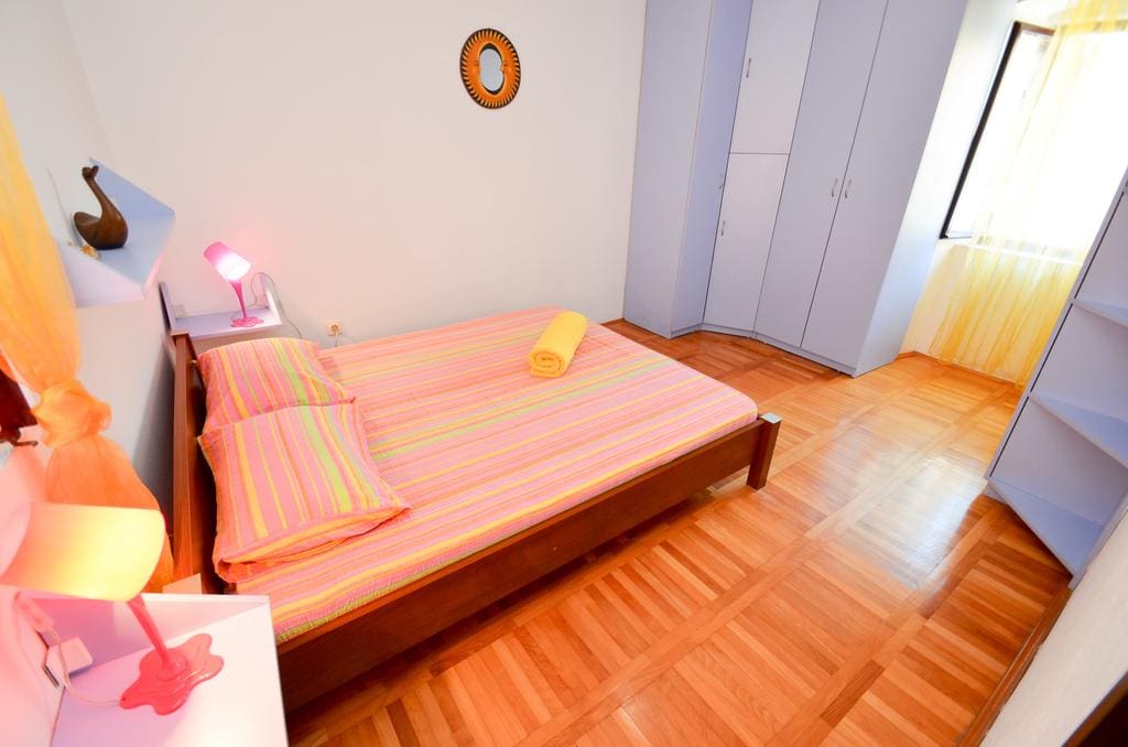 Cozy bedroom with a double bed and parquet flooring in a house for sale, Kotor, Montenegro.