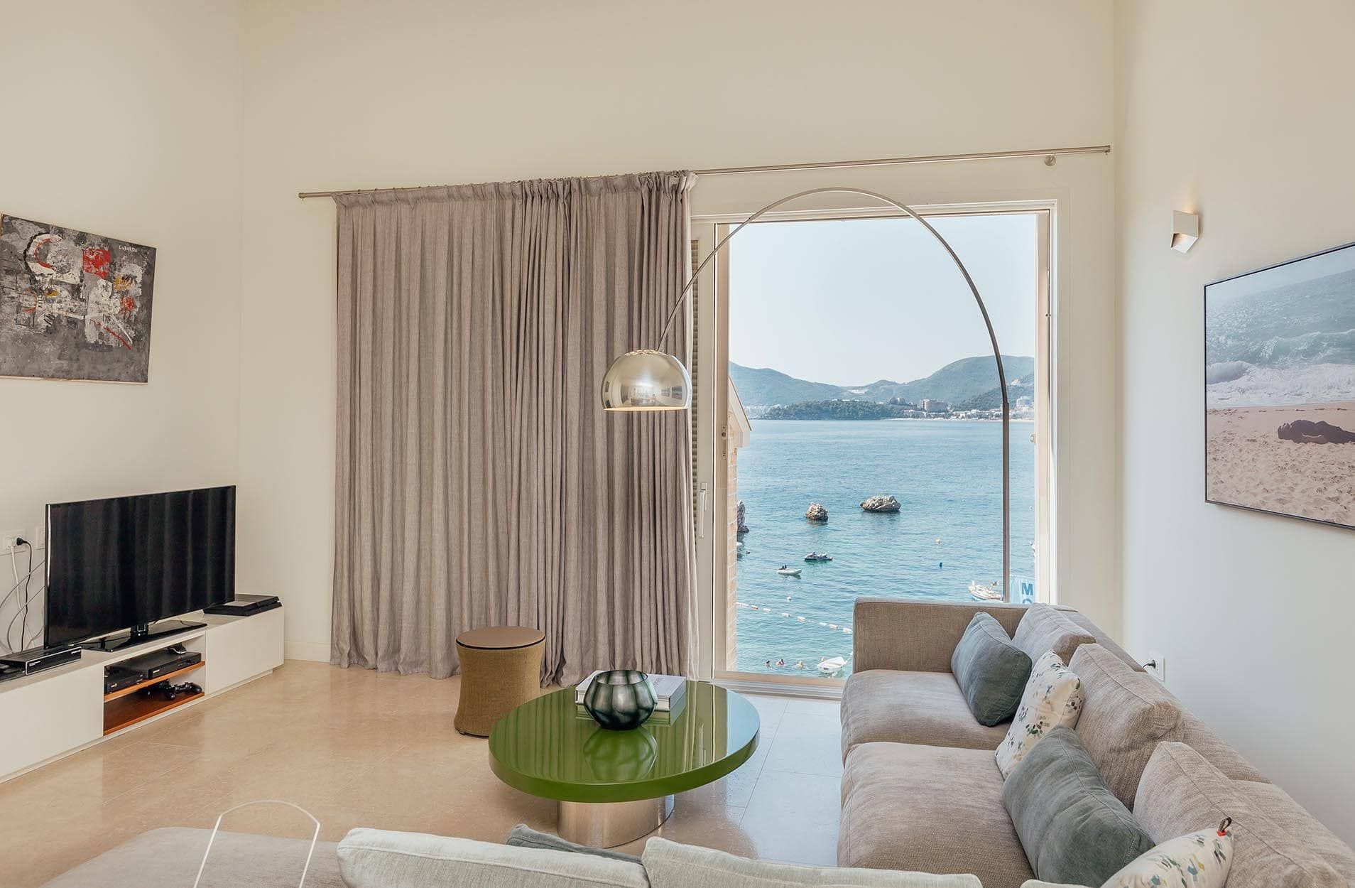 Living room with sea view in a villa in Pržno, Montenegro: modern furniture, panoramic window, and stylish interior.