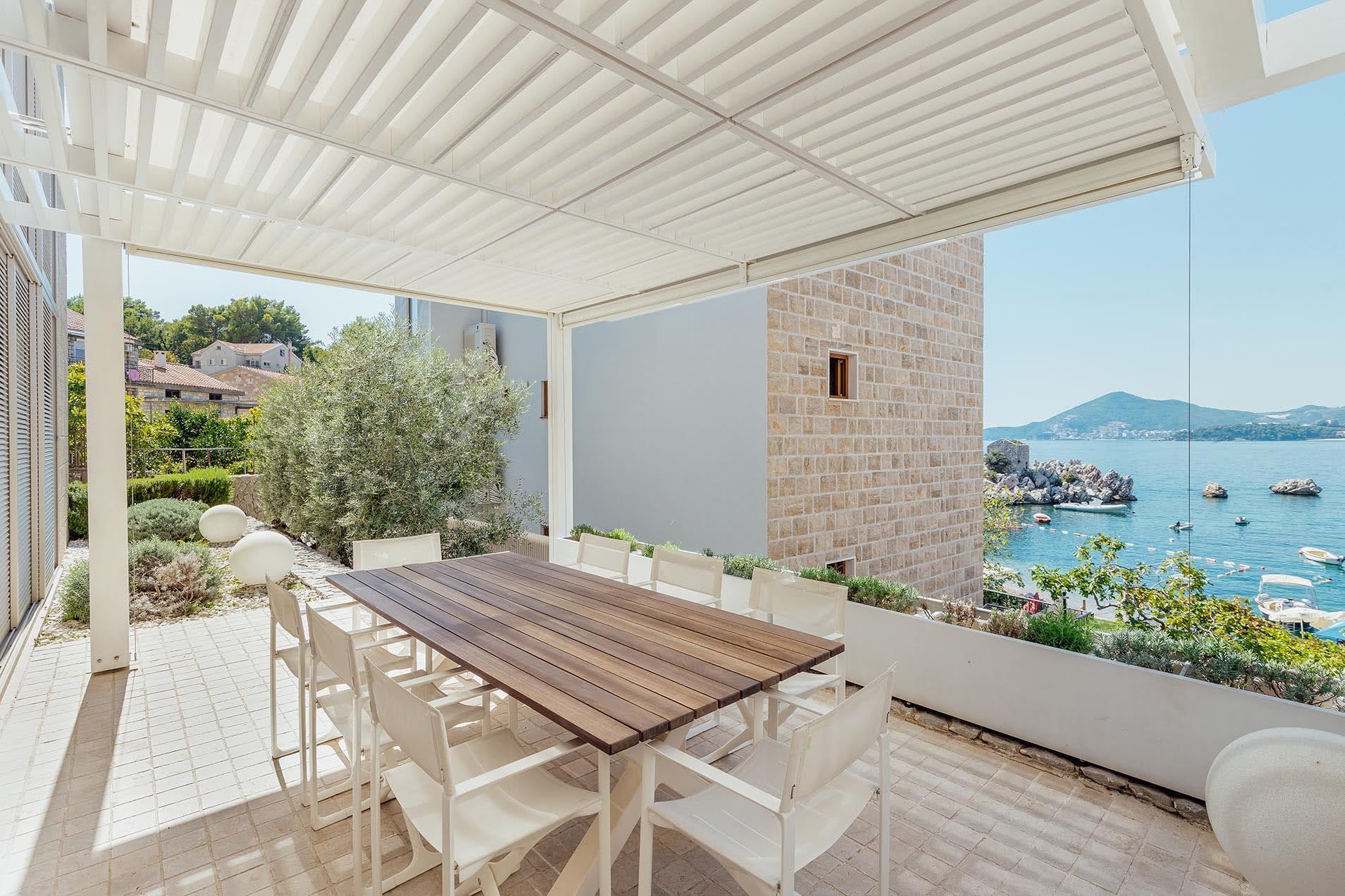 Villa terrace in Pržno, Montenegro: a covered dining area with sea views and coastal stone architecture.