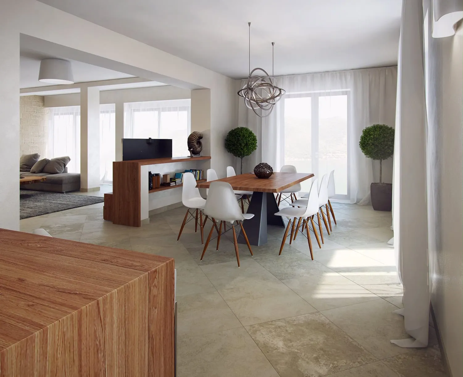 Bright open-plan space featuring a wooden dining table with white chairs and an adjacent living area with a grey sofa visible in the background.