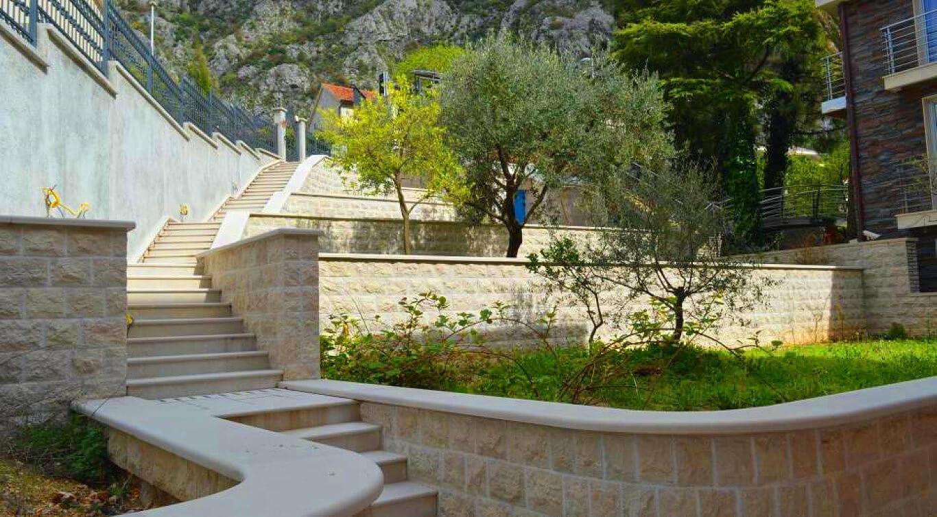 Stone staircase and landscaping with olive trees by a villa in Dobrota, Montenegro.