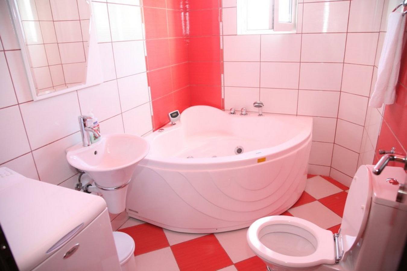 Bathroom with a corner bathtub and red-and-white tiles in a villa in Tivat, Montenegro.