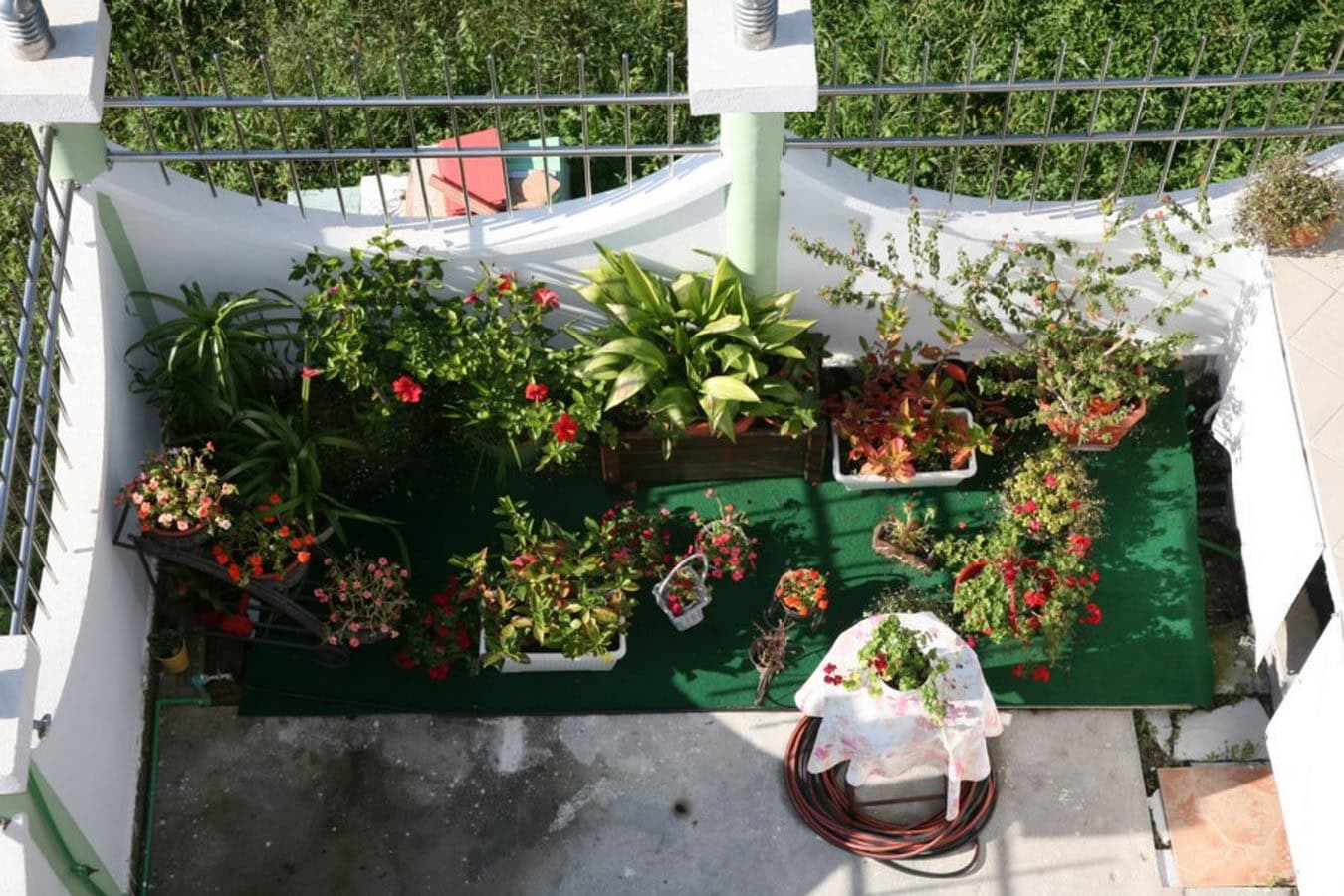 Cozy balcony with many flowering plants on a villa in Tivat, Montenegro, top view of the terrace with flowers.