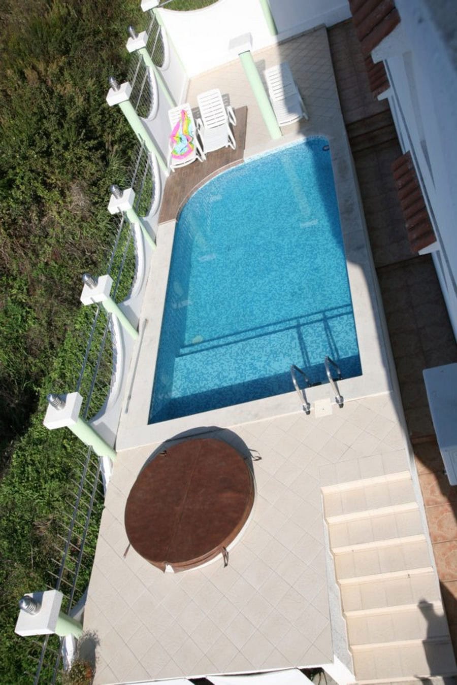 Private pool and jacuzzi on the villa terrace in Tivat, Montenegro, overlooking the green area with sun loungers.