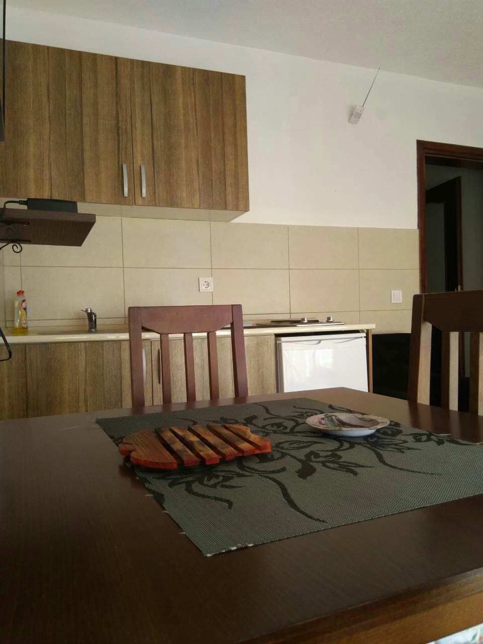 Kitchen with wooden cabinetry and dining area in a house, Shushan, Montenegro. Cozy interior for rental accommodation.