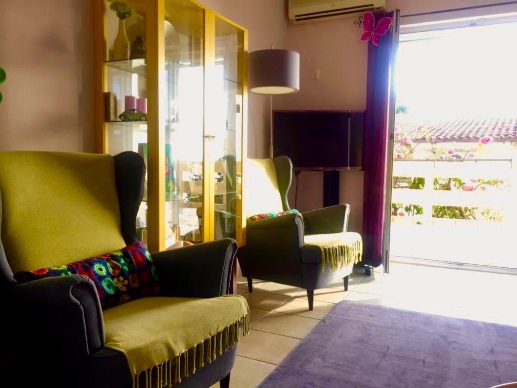 Cozy living room with armchairs and access to the terrace in a villa, Shushan, Montenegro. Interior with a display cabinet and TV area.