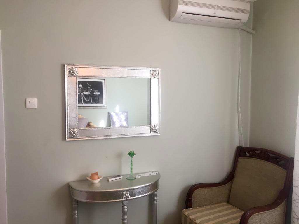 Living room interior in a villa in Shushan, Montenegro: a silver console, framed mirror, armchair, and wall-mounted air conditioner.