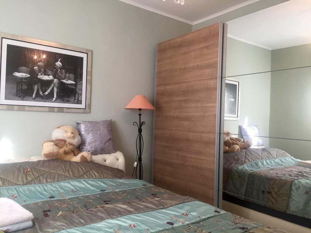 Cozy bedroom with a mirrored wardrobe and a double bed in a villa in Shushan, Montenegro. Modern interior.