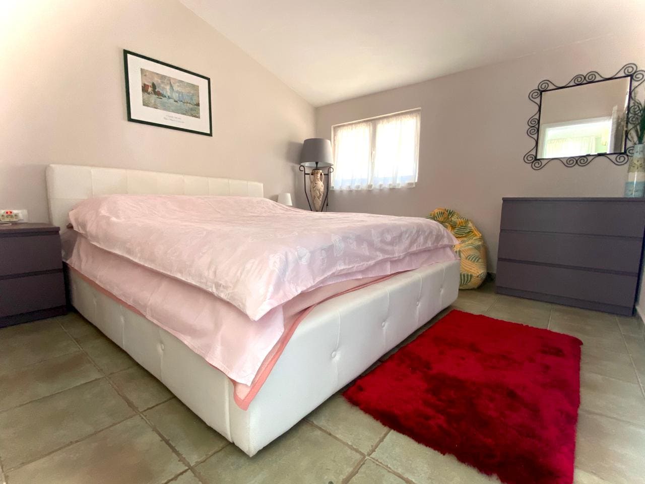 Cozy bedroom with a double bed in a villa, Shushan, Montenegro: light finishes, a dresser and a mirror in the interior.