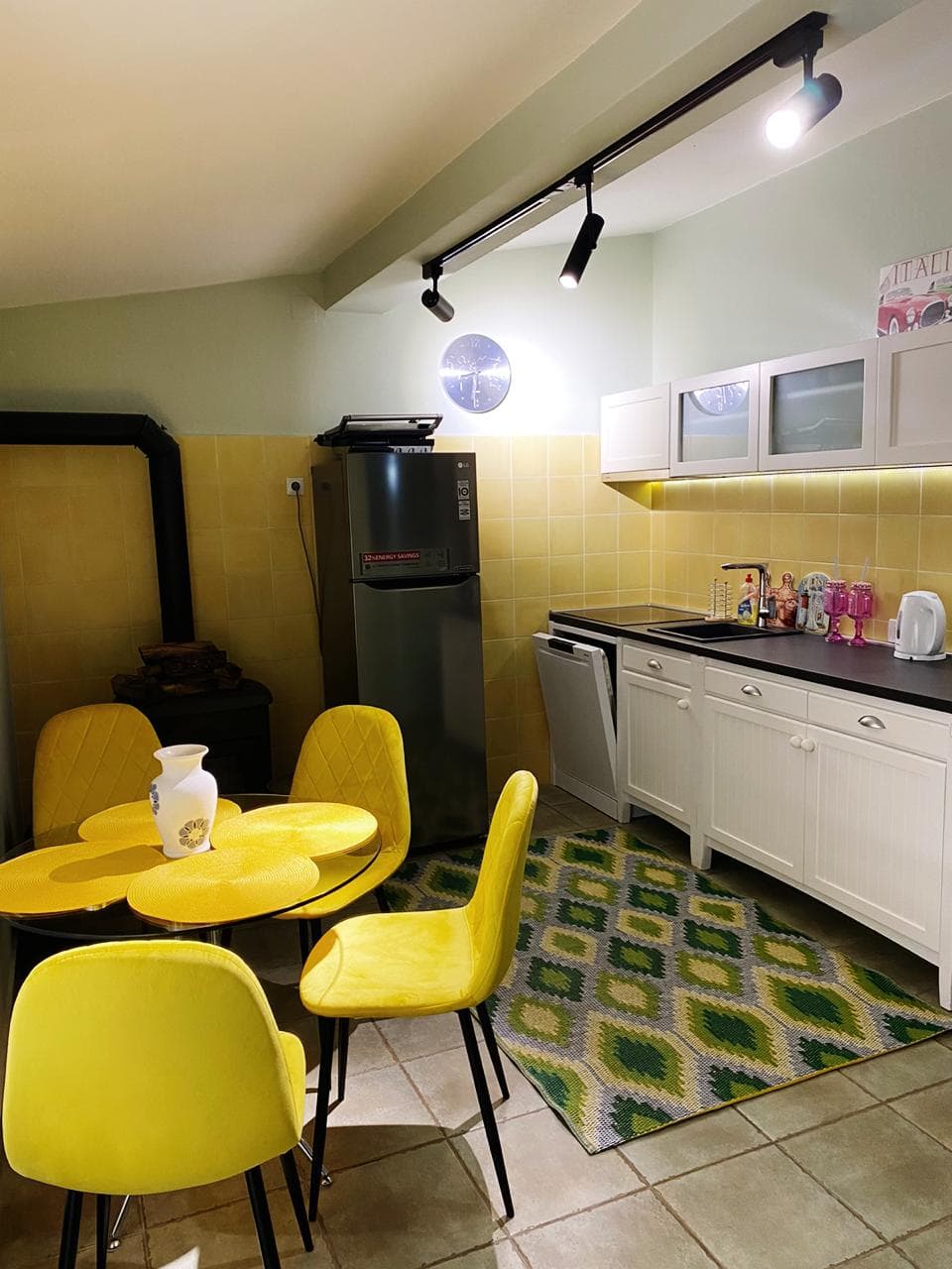 Kitchen with yellow chairs and dining area in a villa in Shushan, Montenegro: modern furniture and appliances.