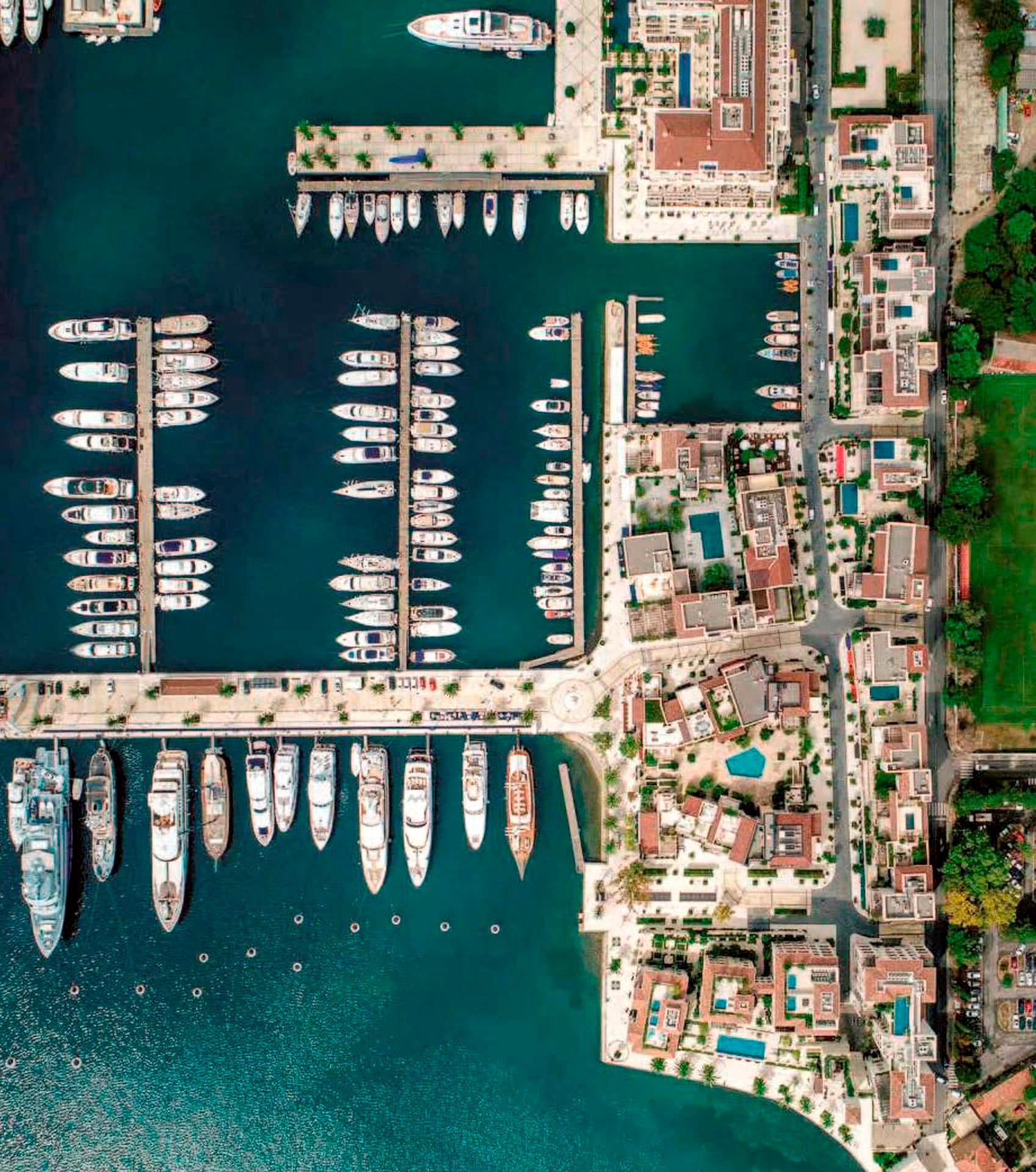 Aerial view of Porto Montenegro marina and Boka Place hotel in Tivat, Montenegro, with docked yachts.