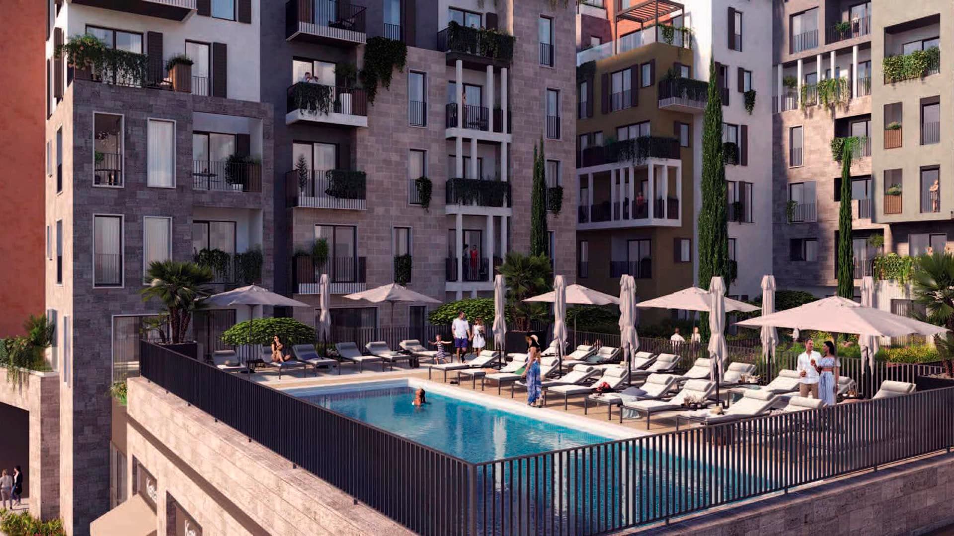 Open-air pool with sun loungers on the terrace of Boka Place hotel in Tivat, Montenegro, with a view of modern architecture.