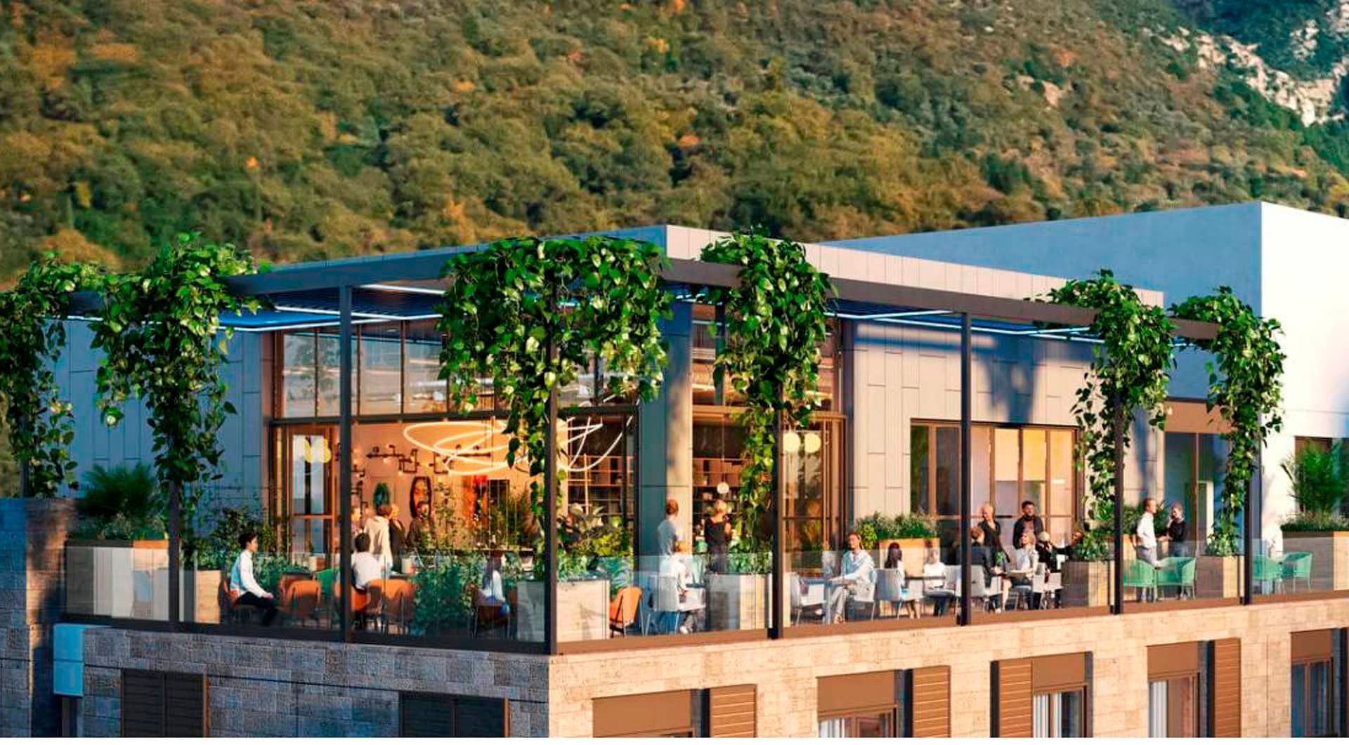 Open terrace of the Boka Place hotel in Tivat, Montenegro: modern architecture, landscaping, and panoramic mountain views.