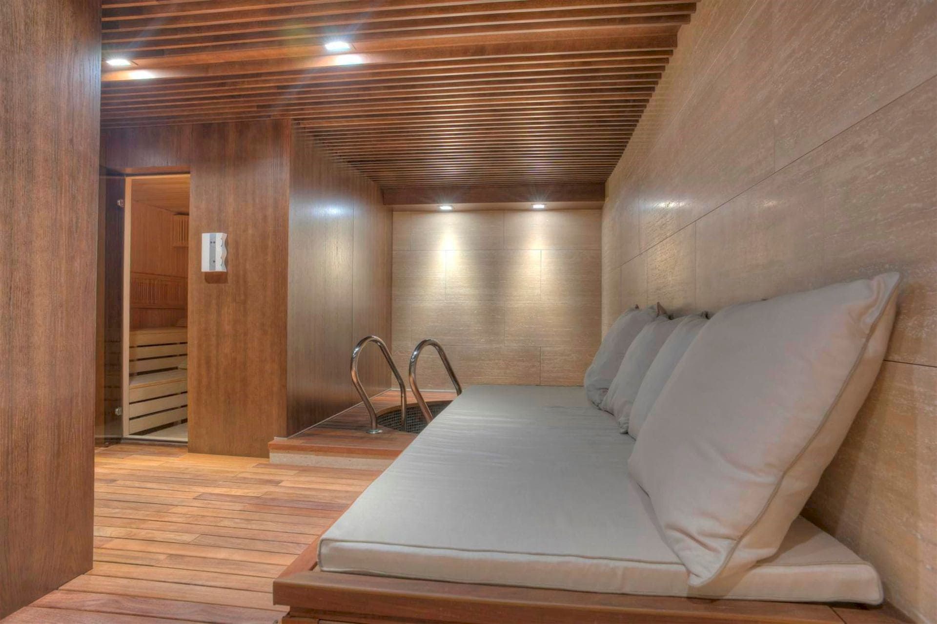 Spa area with sauna and plunge pool in an exclusive villa in Krašići, Montenegro: modern wood finishes and a lounge area.