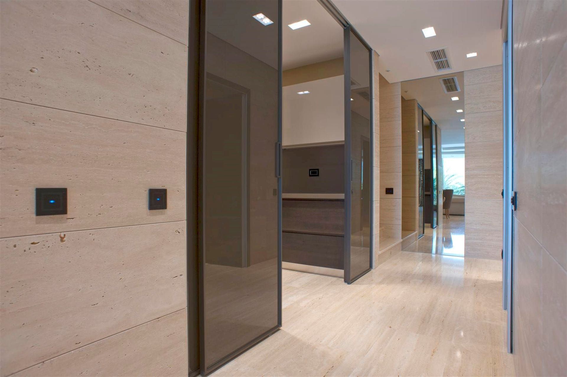 Modern villa interior in Krašići, Montenegro: a living room with natural stone finishes and glass doors.