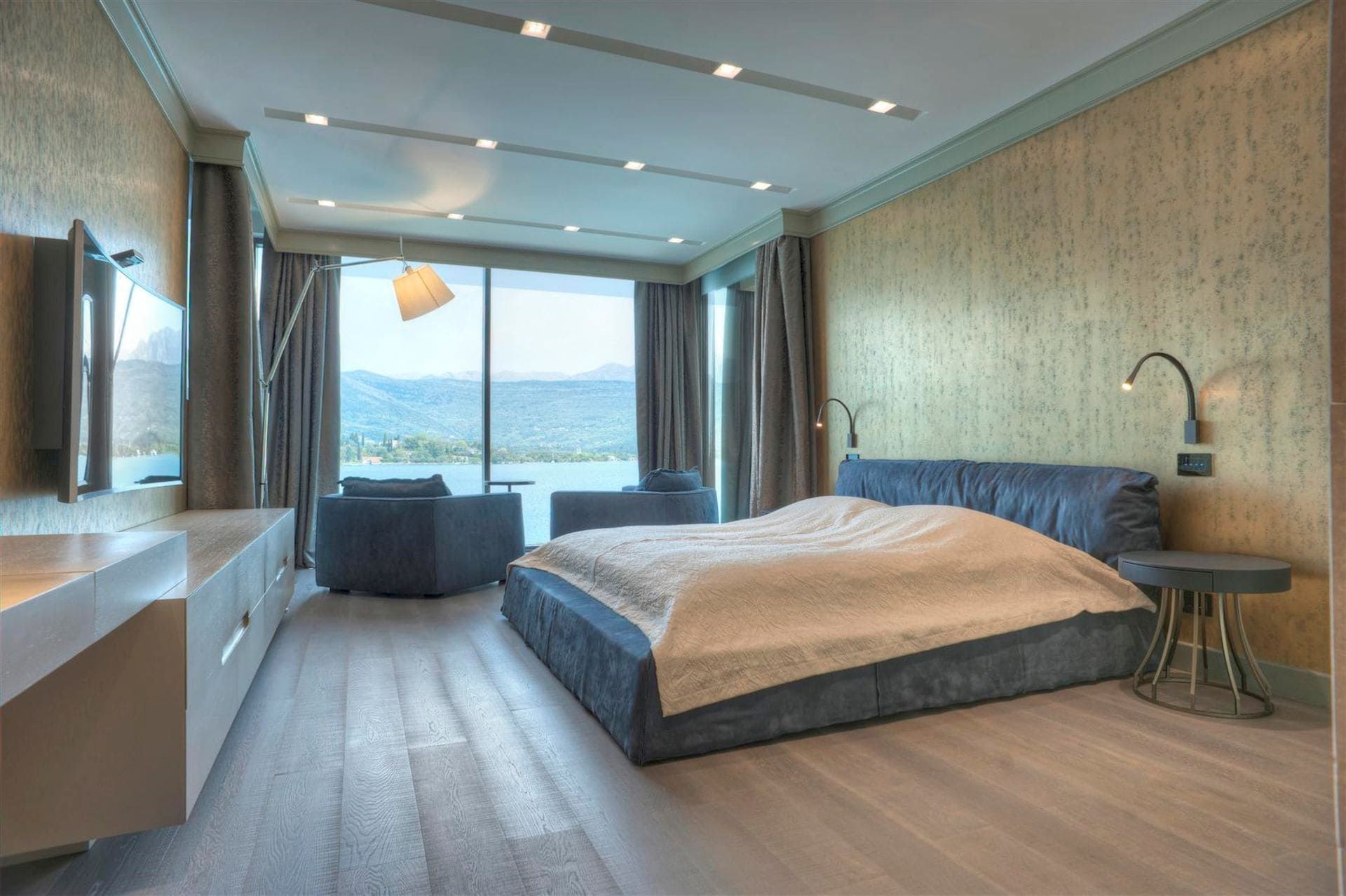 Modern bedroom with sea view in a villa in Krašići, Montenegro: double bed, panoramic windows, and decor.