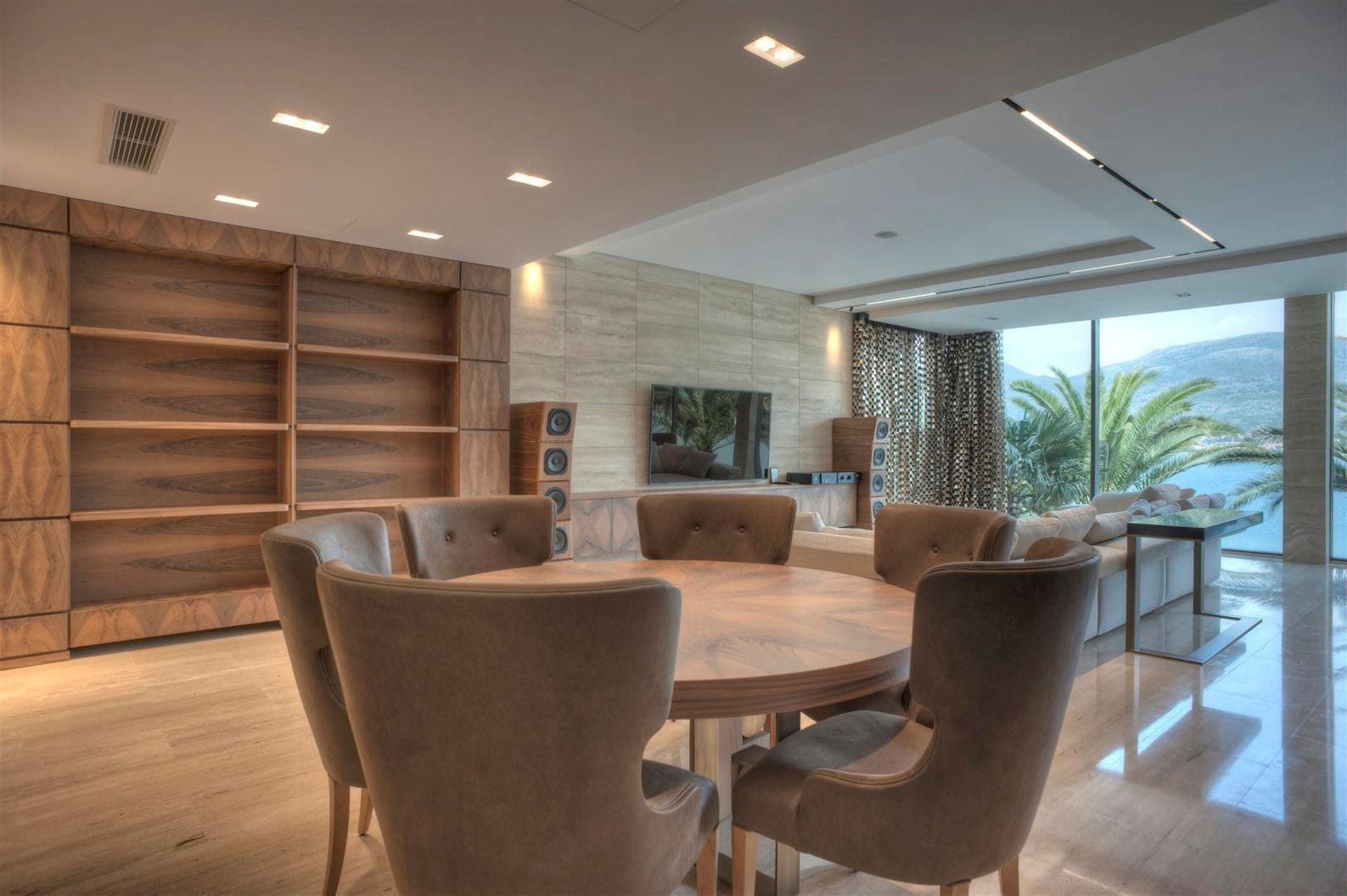Living room with dining area in a villa in Krašići, Montenegro: panoramic windows, sea view, and designer furniture.
