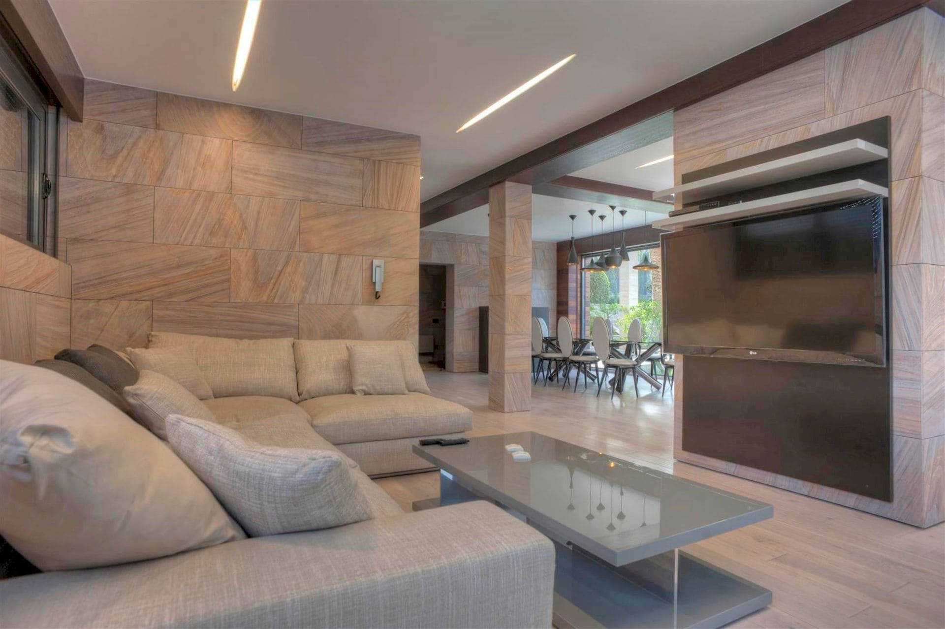 Living room with stone finishes, a soft sofa, and a TV area in a villa in Krašići, Montenegro.