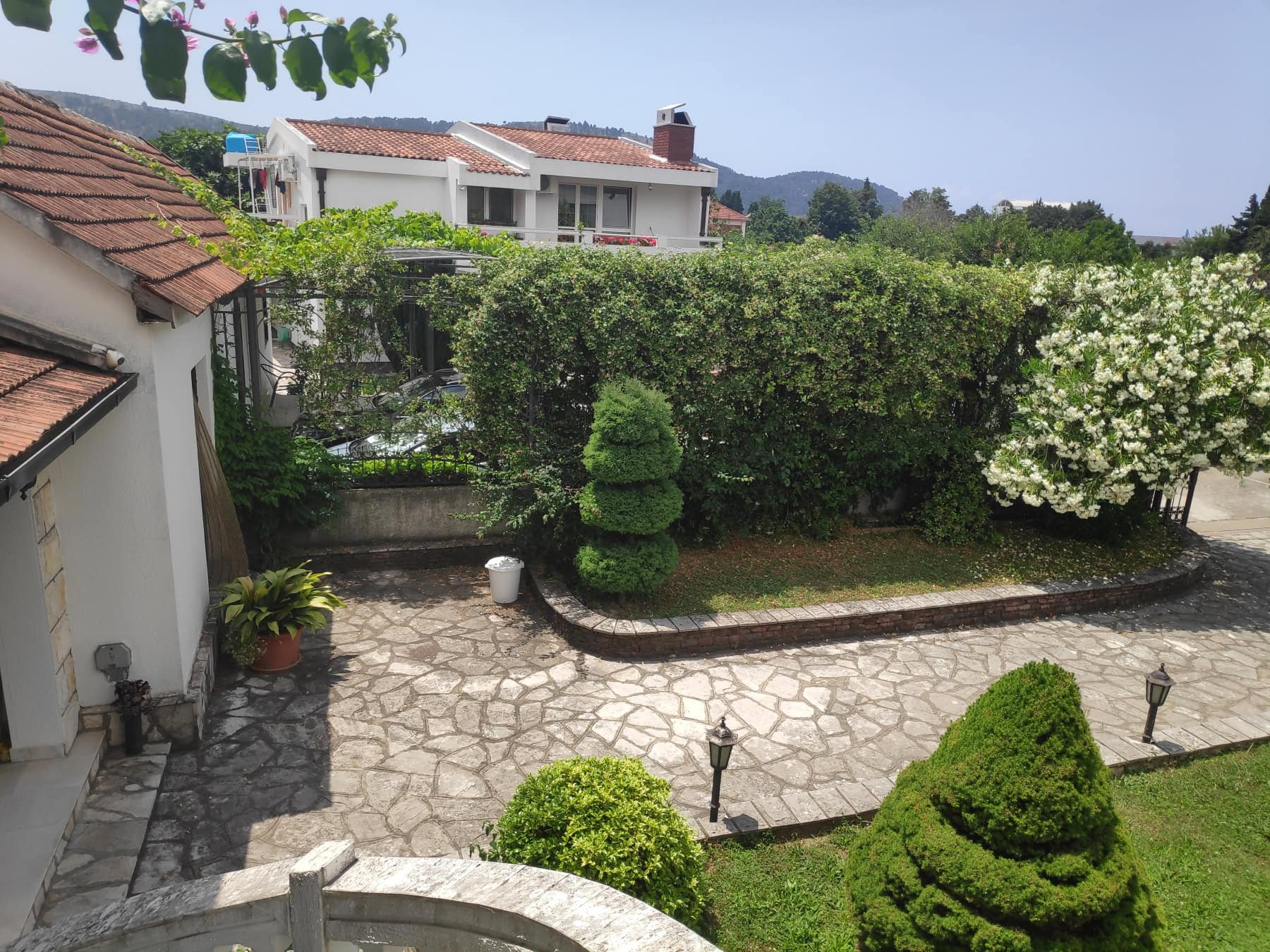 Cozy private house with a green garden and a paved terrace in Bar, Montenegro, view of the yard.