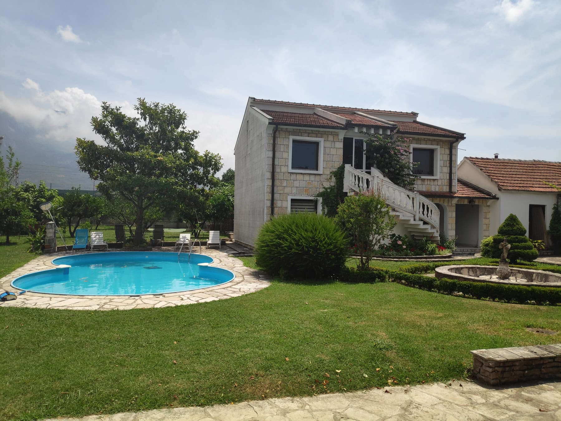 Two-story house in Bar, Montenegro: stone finish, outdoor pool, well-kept garden, and a terrace with stairs.