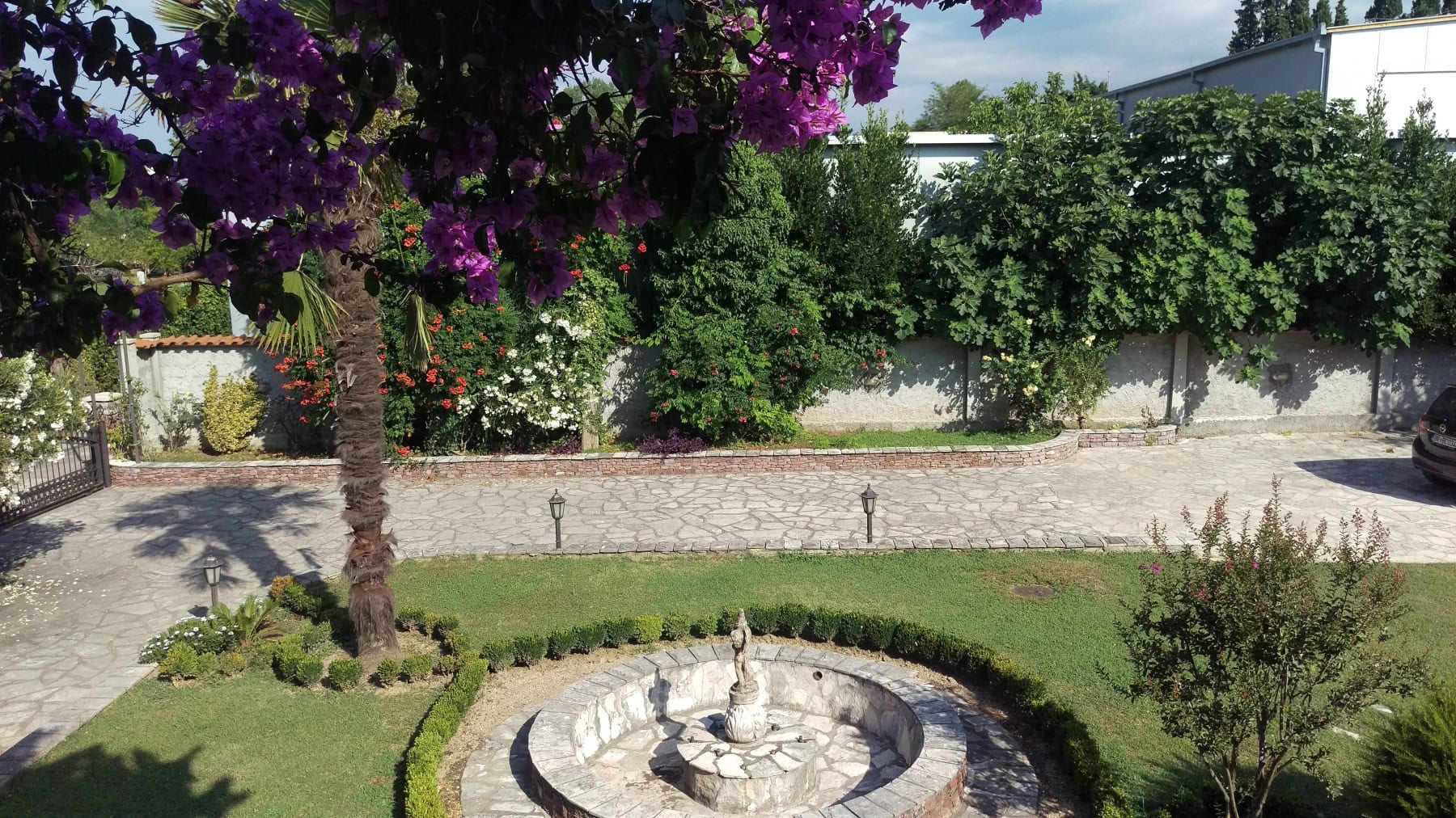Well-kept garden with a fountain and blooming bougainvillea on the grounds of a private house in Bar, Montenegro.