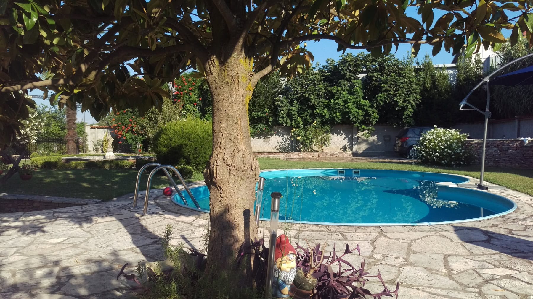 Private house with a pool and a green garden in Bar, Montenegro: a relaxation area with stone paving and landscape design.