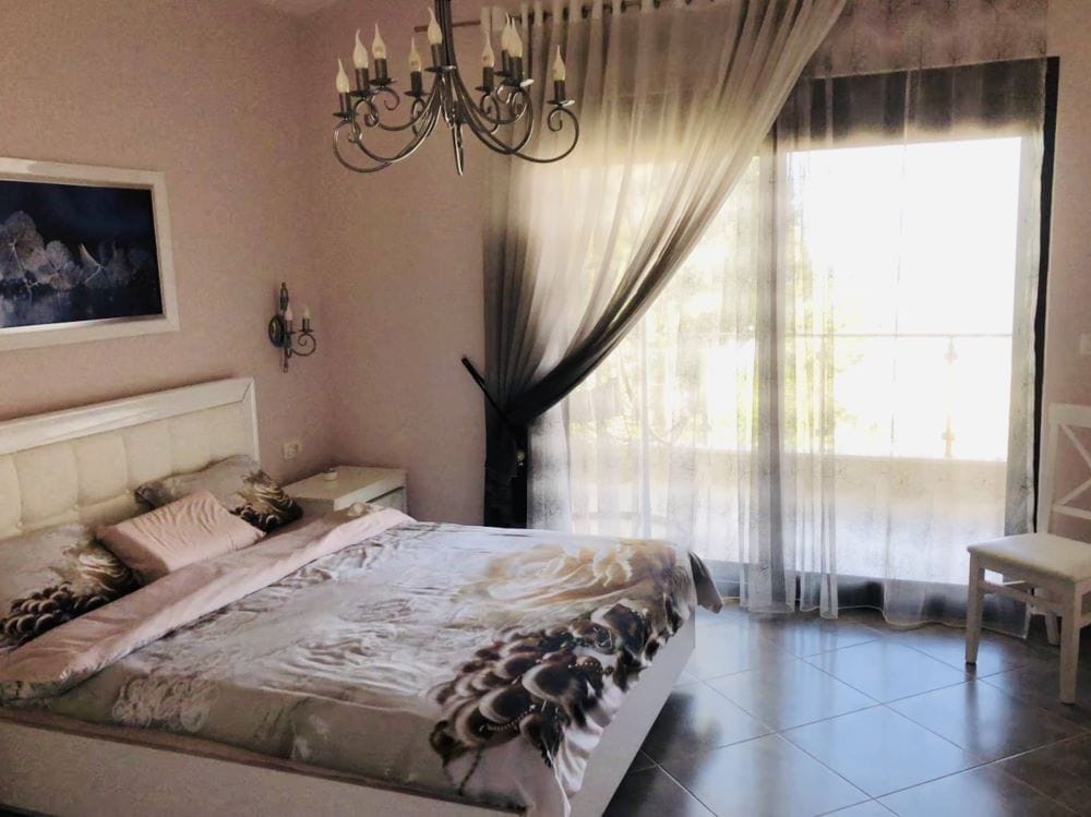 Cozy bedroom with a double bed and a panoramic window in the house, Dobri Vody, Montenegro.
