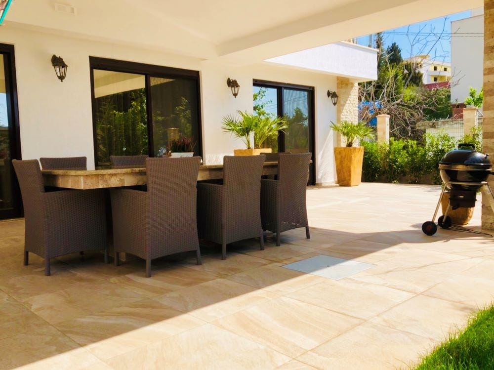 House terrace in Dobri Vody, Montenegro: dining area with rattan furniture, grill, and access to the garden.
